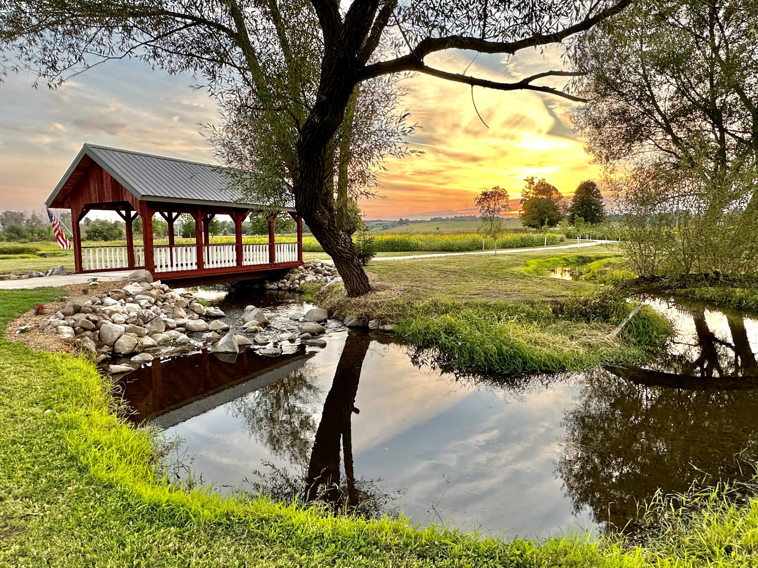 Red covered bridge and creek at sunset at Covered Bridge Estate wedding and event venue in Kettle Moraine, Wisconsin